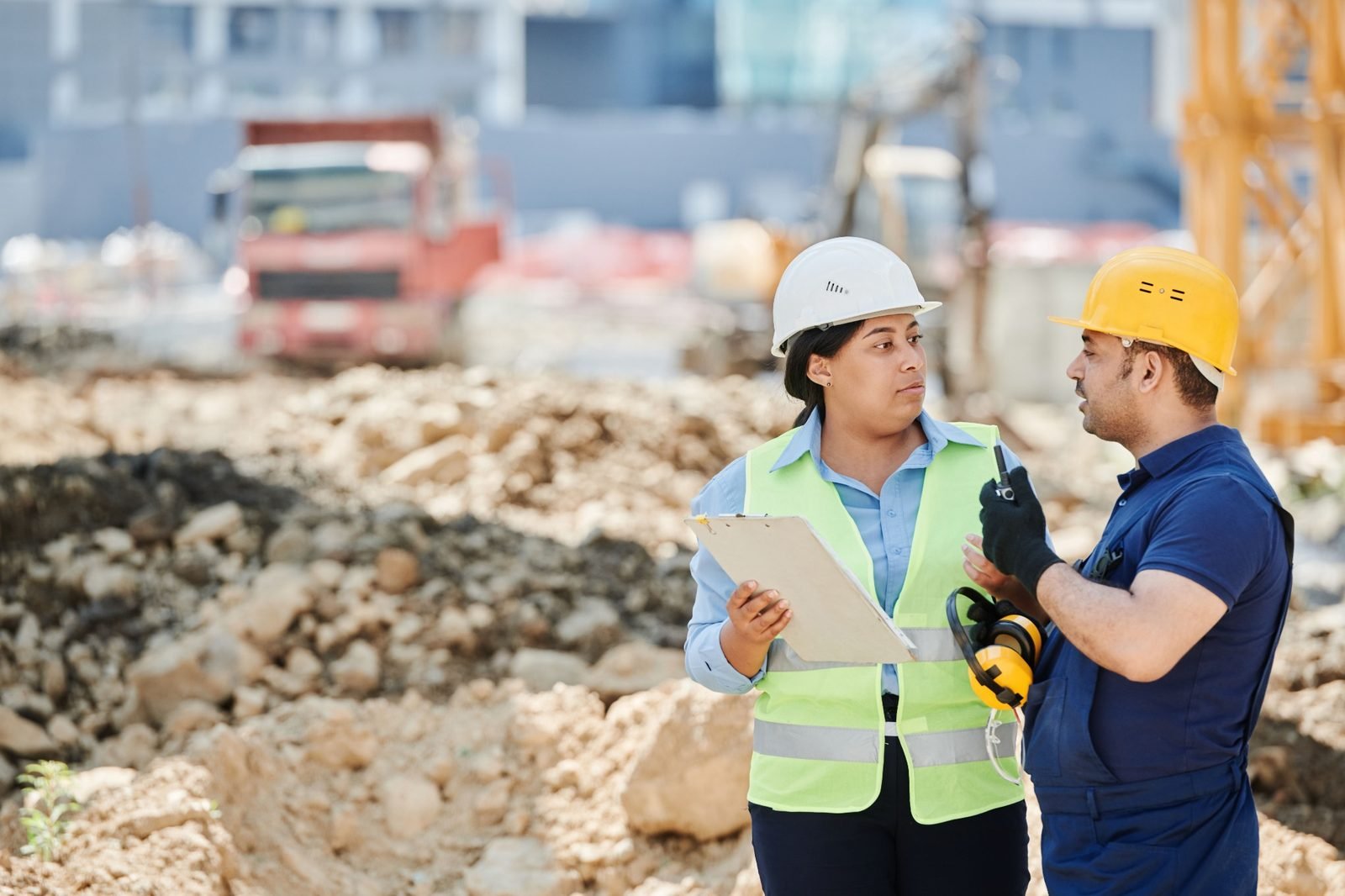 Two professionals reviewing work at an active construction site